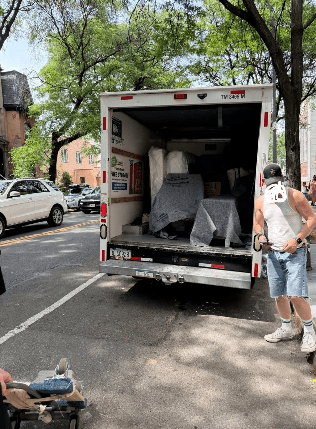 Moving truck loaded with wrapped furniture on a city street