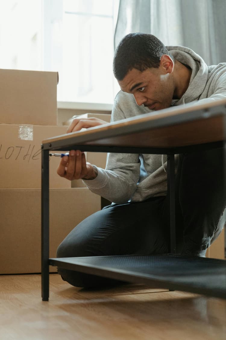 Man assembling flatpack furniture in an apartment