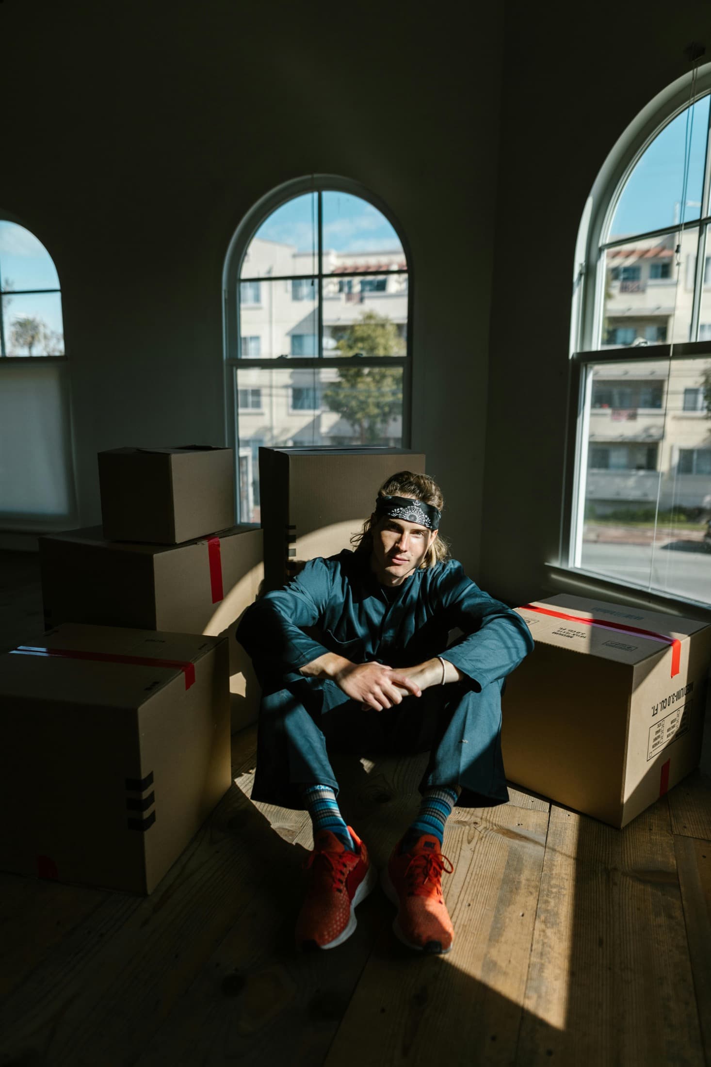 Man sitting with moving boxes in a new apartment